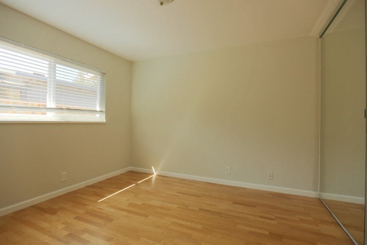 a room with a wooden floor and a window