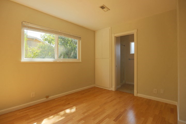 an empty room with a window and a wooden floor