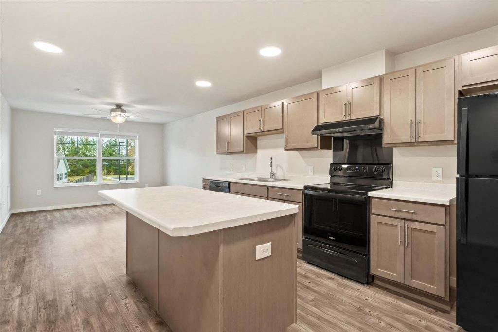 a kitchen with an island and a black stove and refrigerator