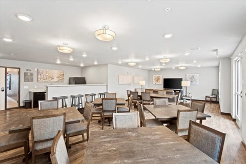 a large dining room with tables and chairs and a kitchen