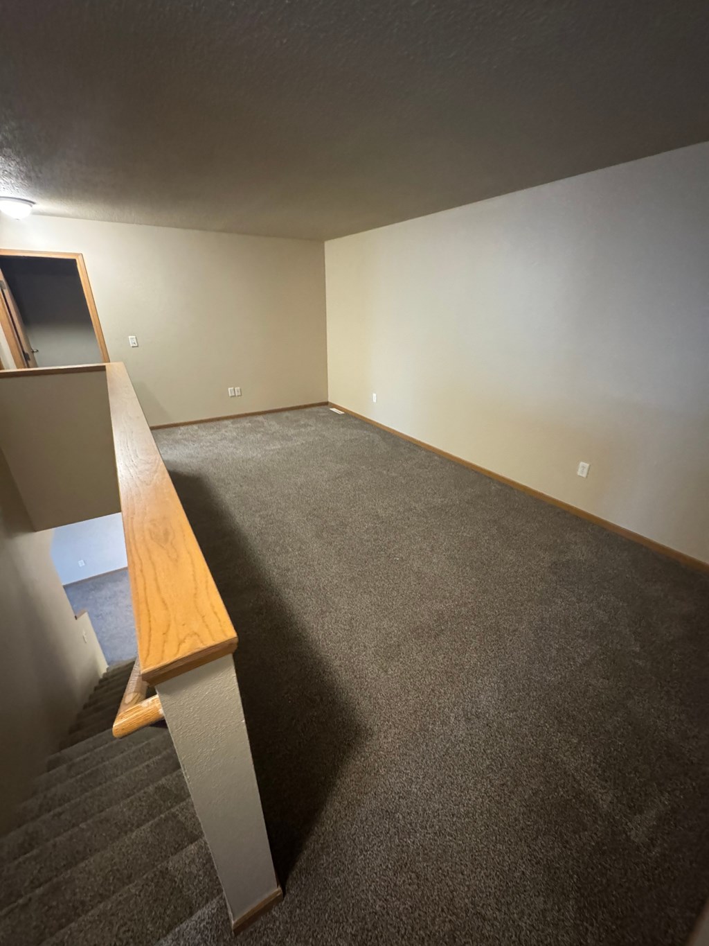 A room with a carpeted floor and a wooden bench.