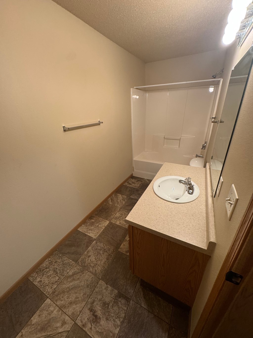 A bathroom with a sink, mirror, and towel rack.