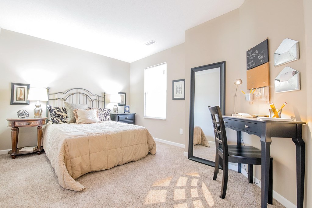 a bedroom with a bed and a desk with a mirror