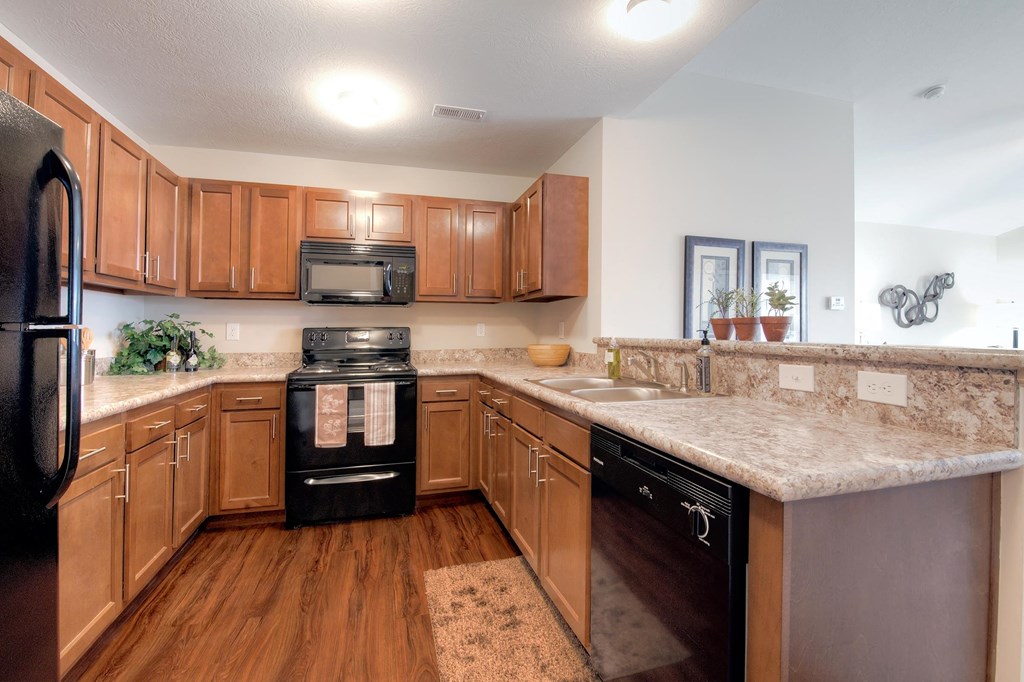 a kitchen with wooden cabinets and granite counter tops