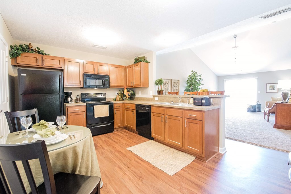 a kitchen with wooden cabinets and black appliances