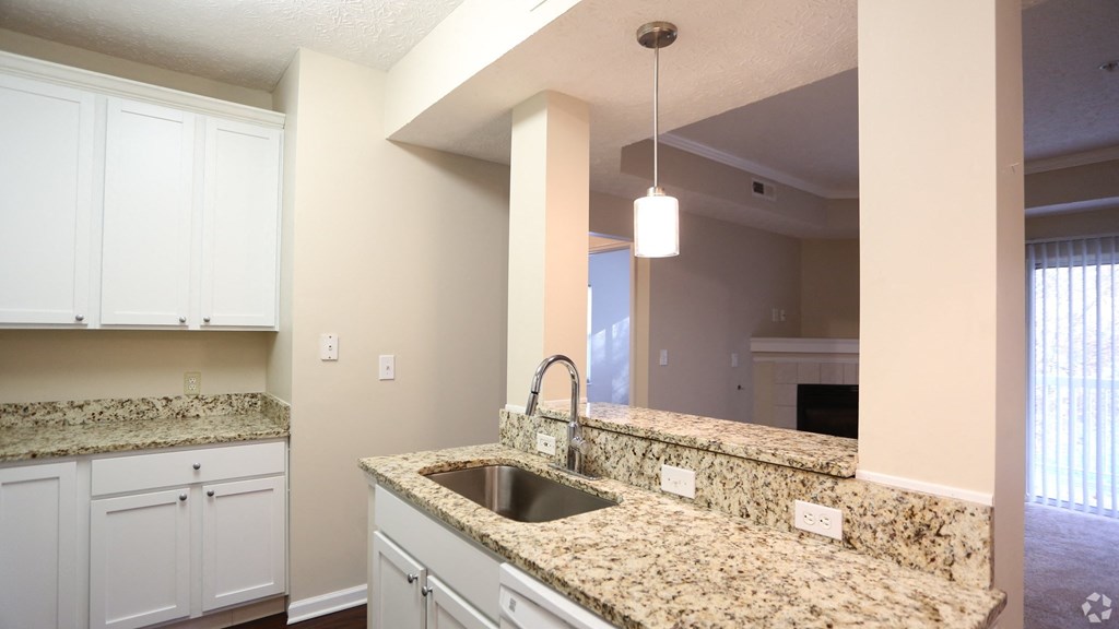 a kitchen with granite counter tops and white cabinets