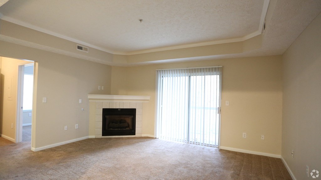 an empty living room with a fireplace and a window