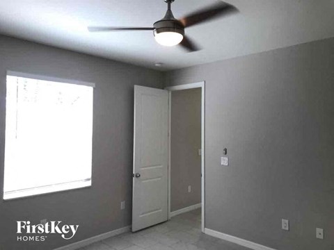 an empty room with a ceiling fan and a door