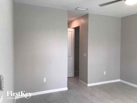 an empty room with a hallway and a door to a closet