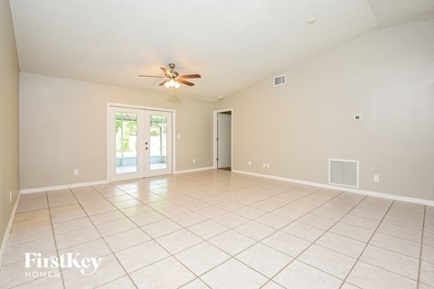 A spacious room with a ceiling fan and sliding glass doors.