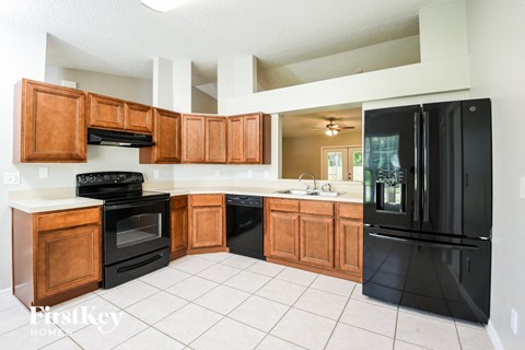 A kitchen with black appliances and wooden cabinets.
