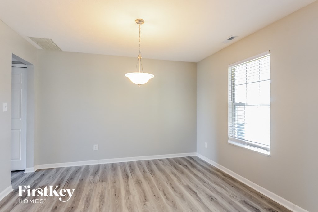 the living room of a new home with wood flooring and a window