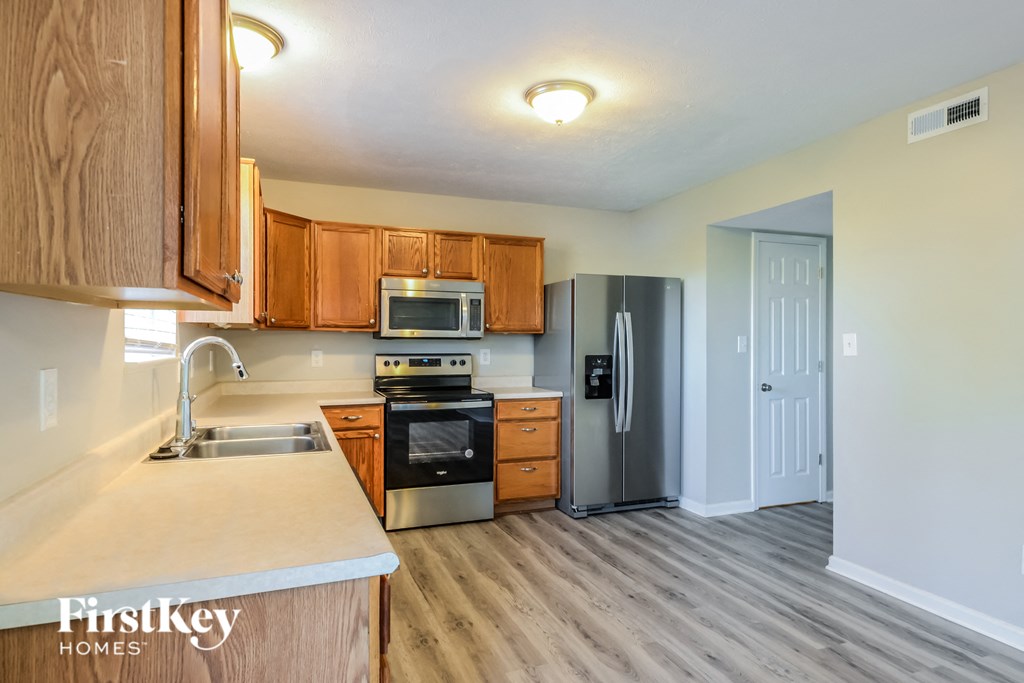 a kitchen with wooden cabinets and stainless steel appliances