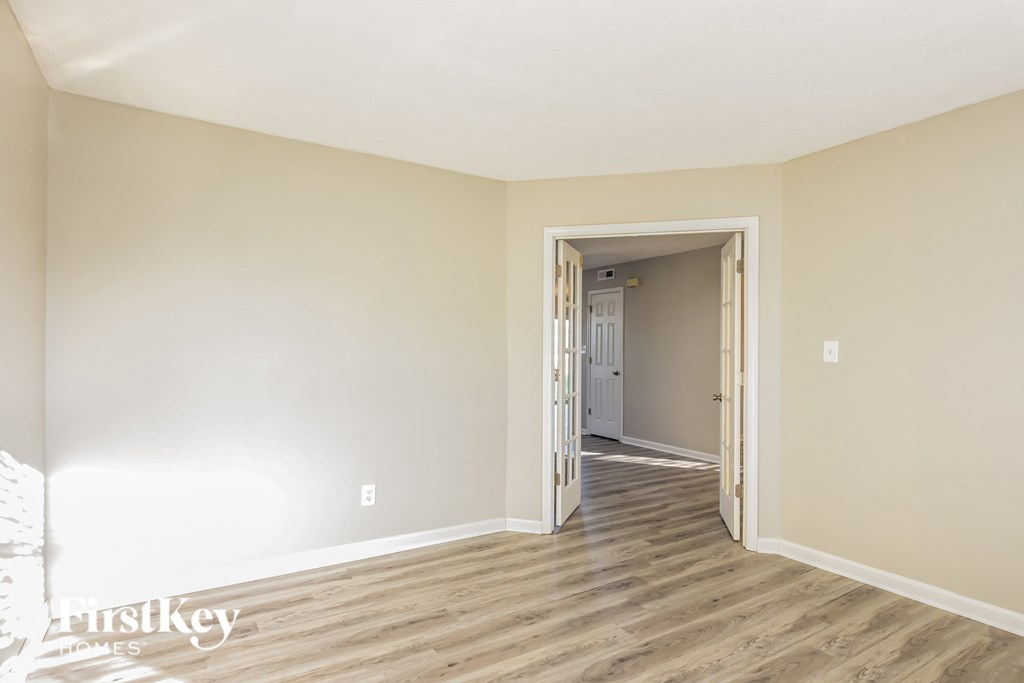 a living room with wood floors and white walls