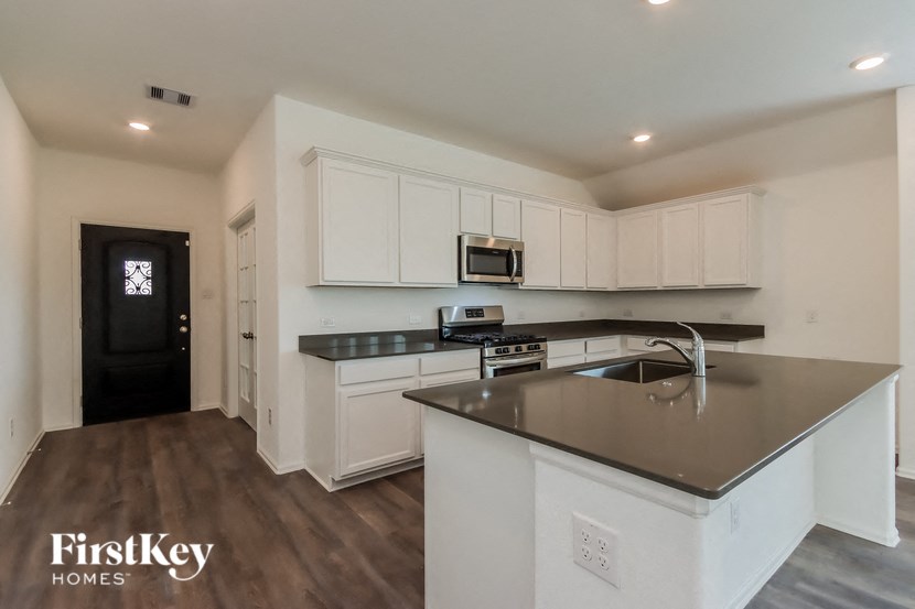 a kitchen with white cabinets and stainless steel counter tops