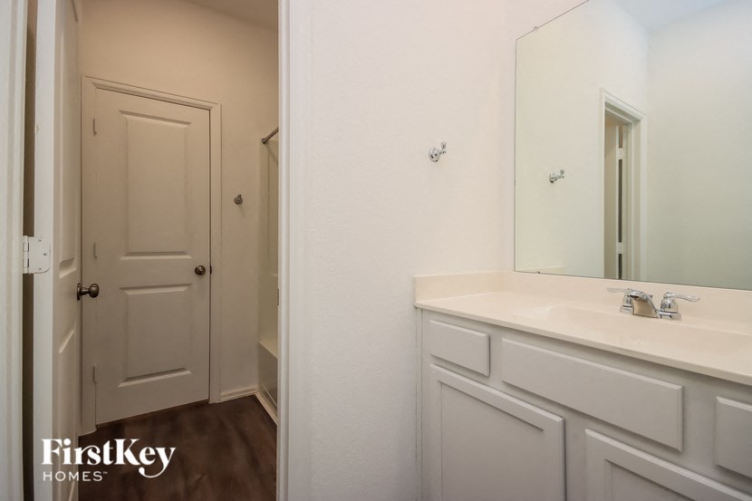 a bathroom with white cabinets and a sink and a mirror