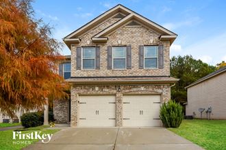 a brick house with two garage doors in front of it