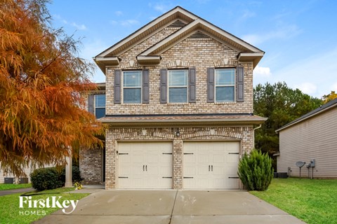 a brick house with two garage doors in front of it