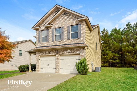 a tan brick house with a white garage door