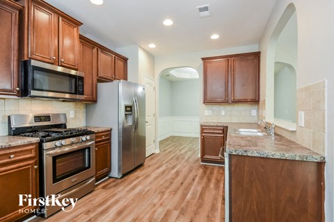 a kitchen with wooden cabinets and stainless steel appliances