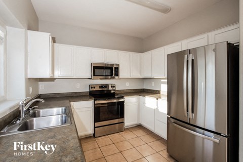 a kitchen with white cabinets and stainless steel appliances