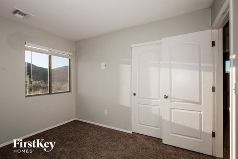 a bedroom with two white doors and a window