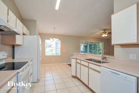 a kitchen with white cabinets and a sink and a refrigerator