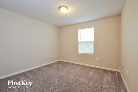 the upstairs bedroom with carpet and a window
