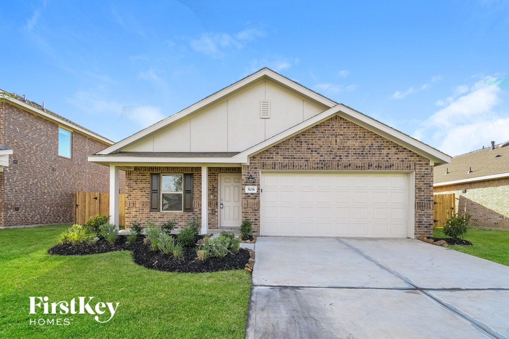 A house with a garage and a driveway in front of it.