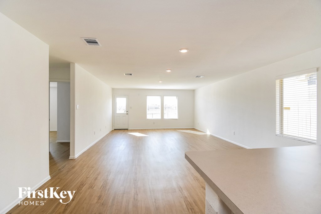A spacious room with wooden floors and white walls.