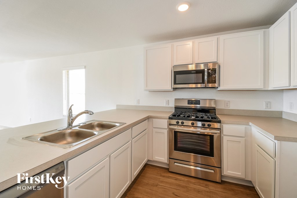 A kitchen with white cabinets and a stainless steel oven.