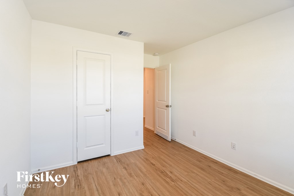 A room with a white door and a wooden floor.
