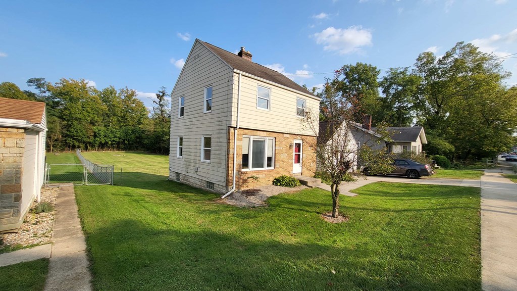 a house with a yard and a car parked in front of it