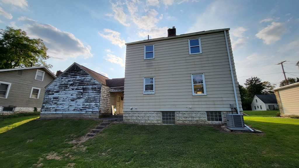 the back of a house with a stone chimney on the side of it