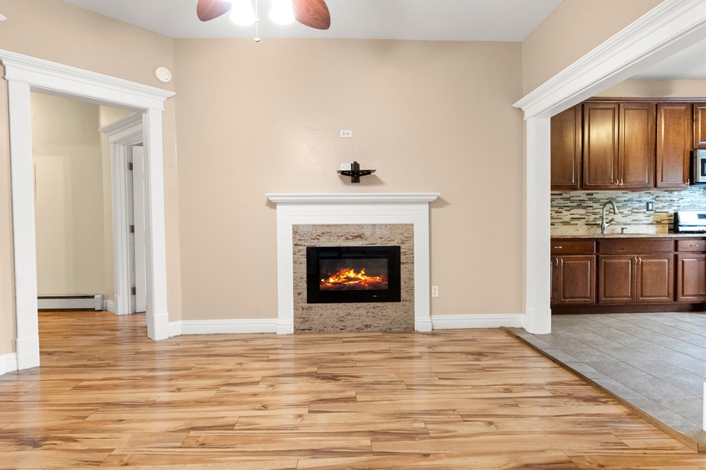 A living room with a fireplace and wooden floors.