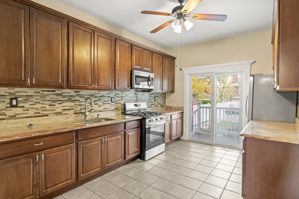 A kitchen with wooden cabinets and a tile backsplash.