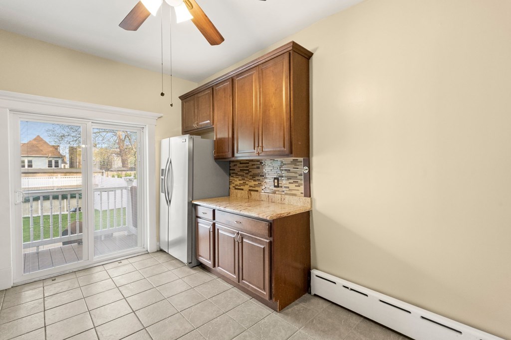 A kitchen with brown cabinets and a white refrigerator.