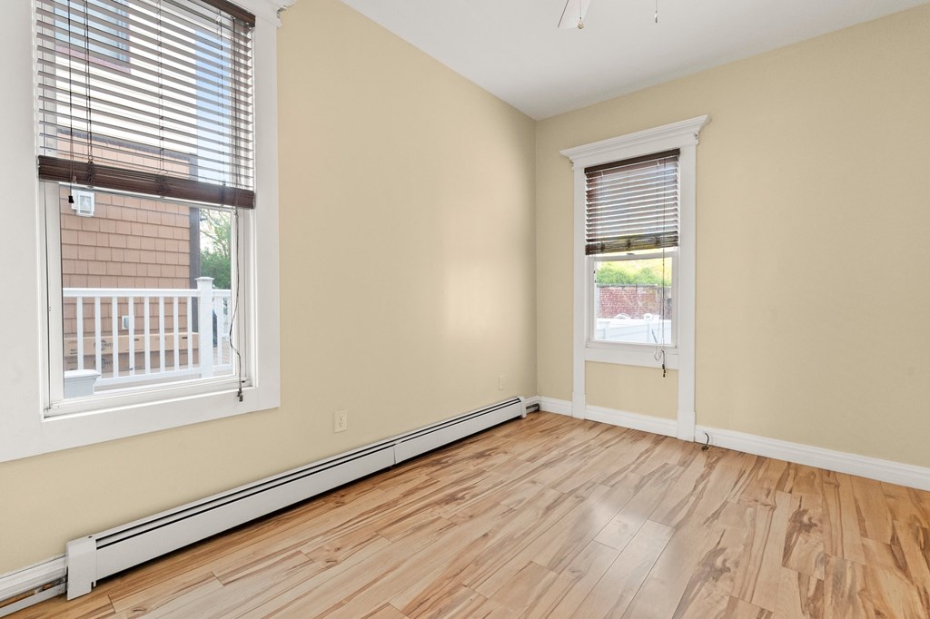 A room with wooden floors and two windows.