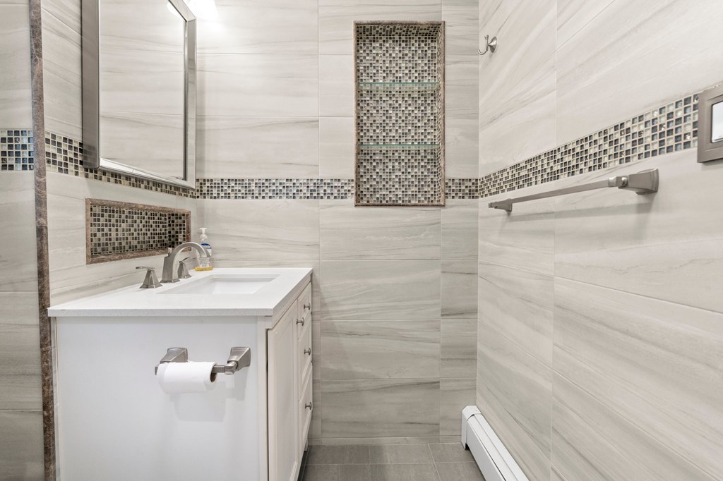 A bathroom with a white sink and a white cabinet.