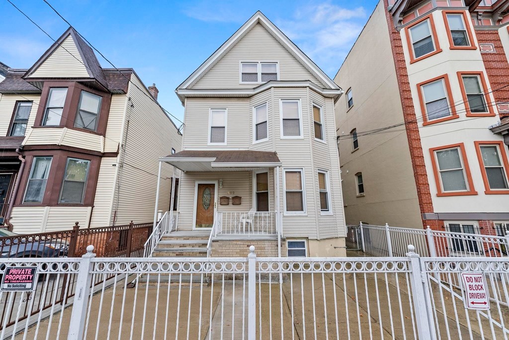 A house with a white fence in front of it.