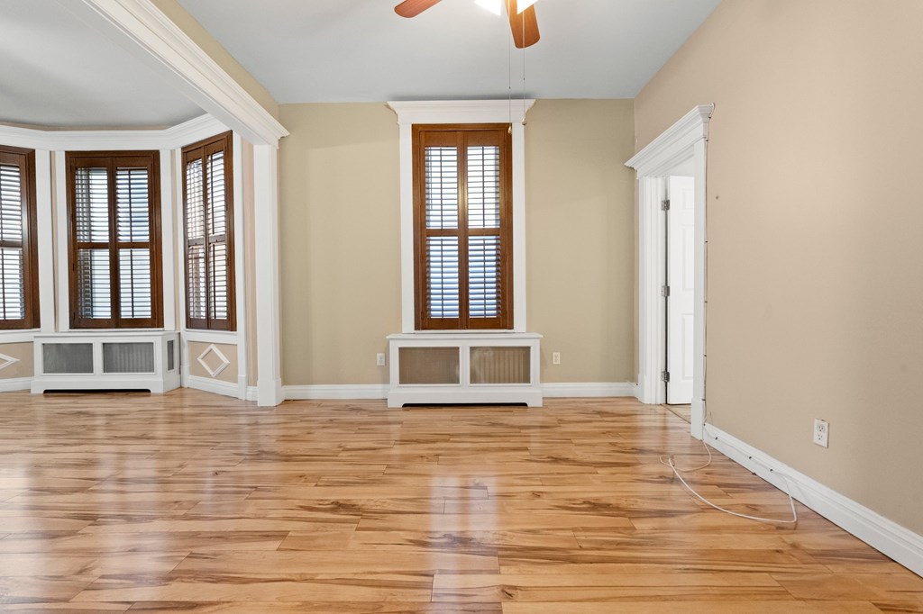 A room with wooden floors and a ceiling fan.