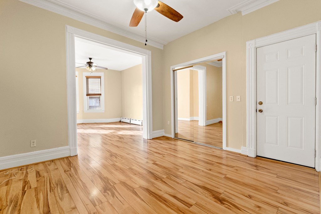 A room with wooden floors and a ceiling fan.