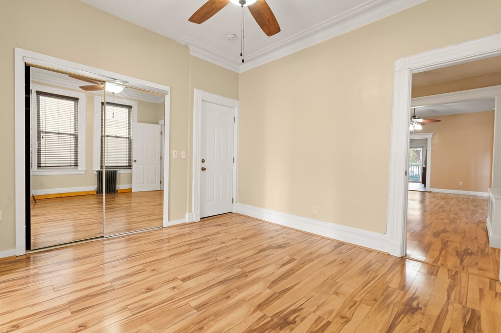 A room with wooden floors and a ceiling fan.
