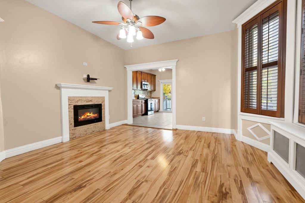 A room with a fireplace and wood flooring.