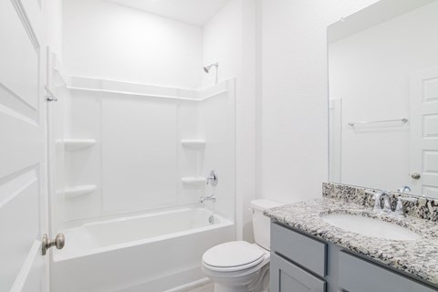 A white bathroom with a toilet, sink, and bathtub.