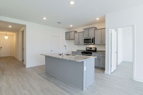 A modern kitchen with a granite countertop and stainless steel appliances.