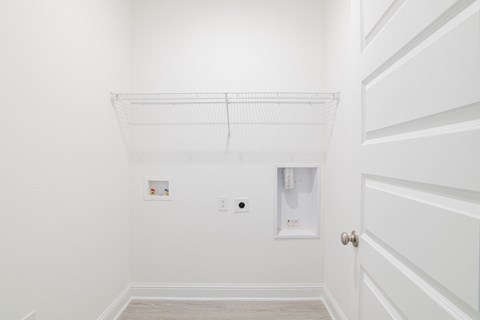 A white wall with a shelf and a door.