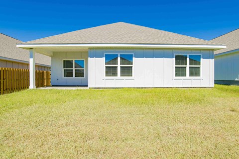A white house with a brown fence in front of it.