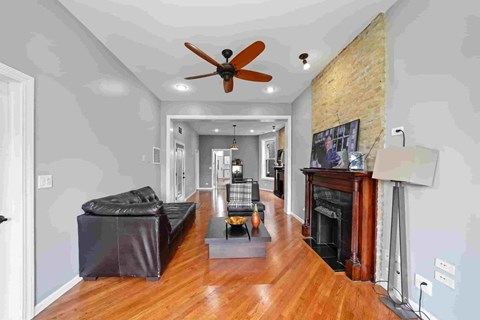 A living room with a black couch and a fireplace.