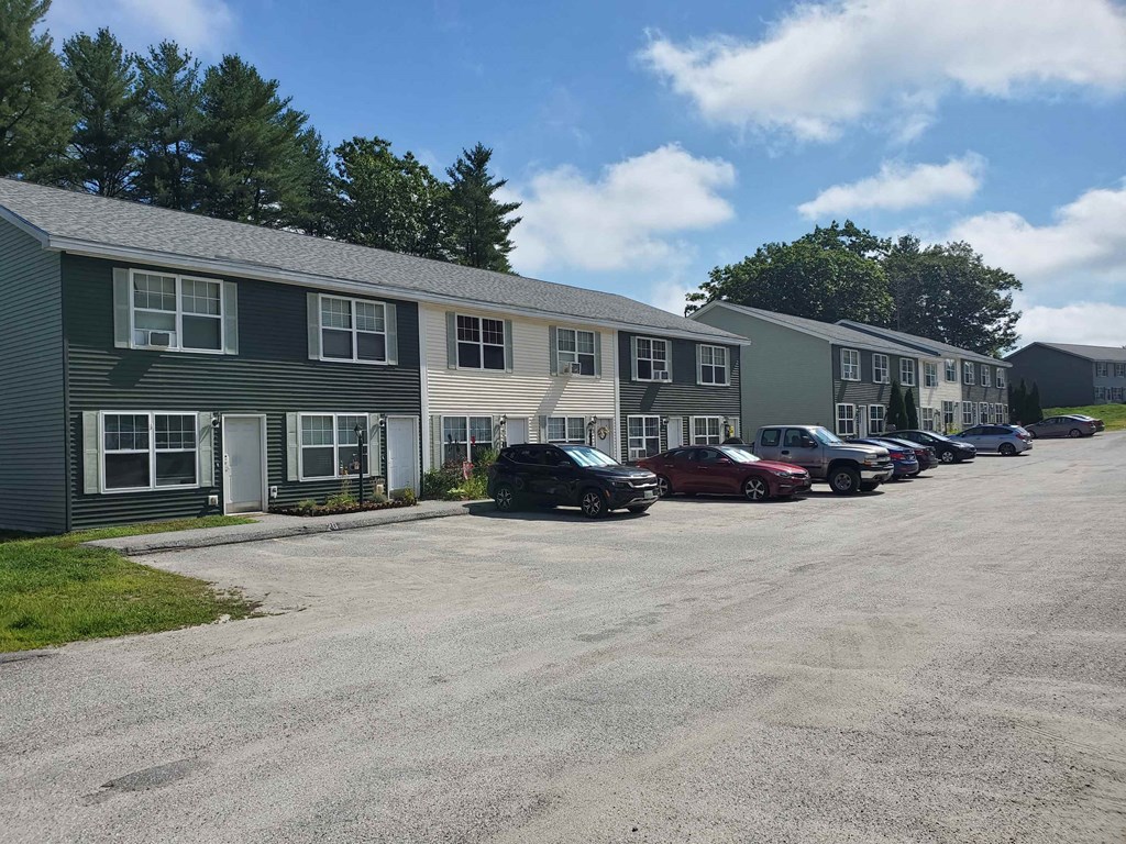 a parking lot in front of a building with cars parked in front